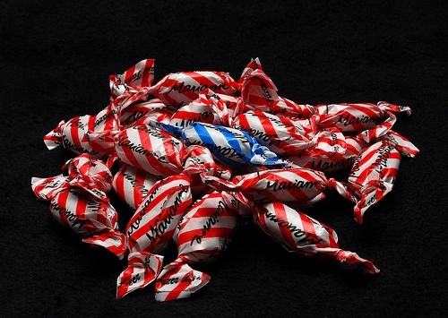 One blue sweet amongst red sweets.