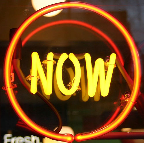 Neon sign that reads 'NOW'.