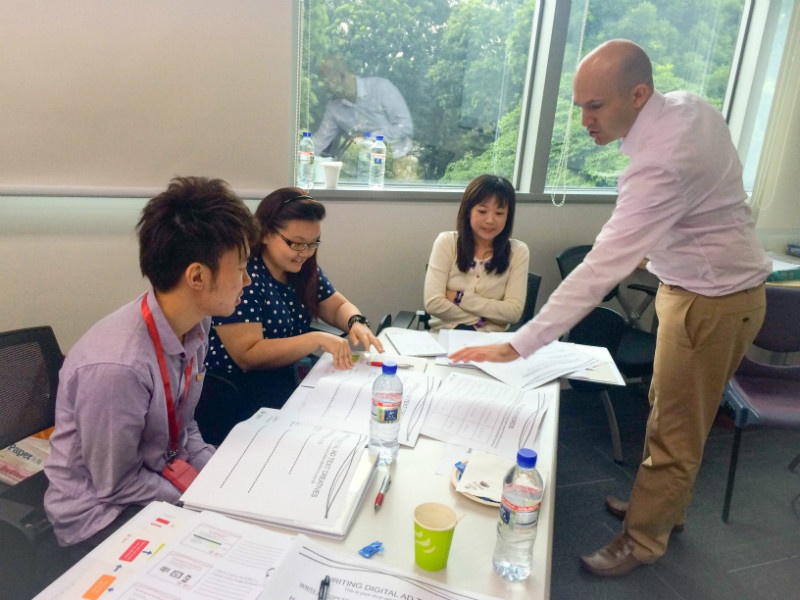 Phil Robinson delivers digital marketing training to a group at a table.