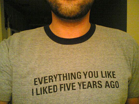 A man wearing a shirt with the slogan 'Everything you like, I liked five years ago'.