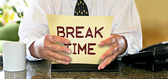 Man holding sign reading 'Break Time'.