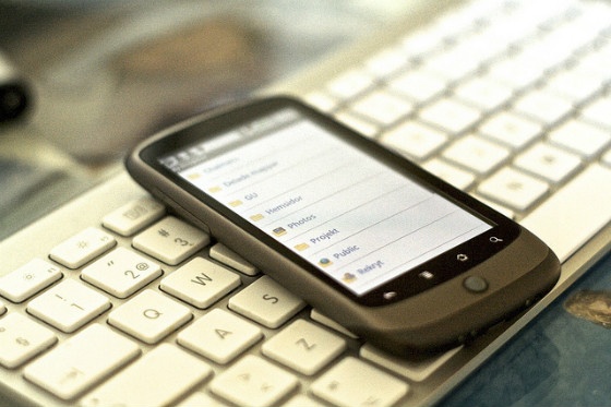 A smartphone resting on a desktop keyboard.