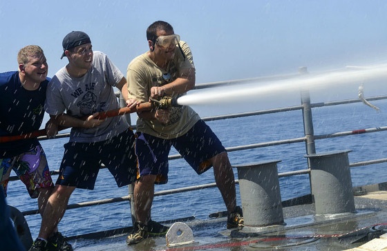 Sailors manning a firehose.